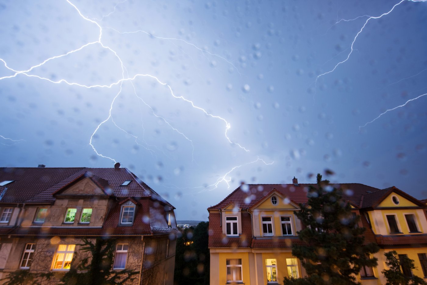 lyn fra blå himmel over boligblokker