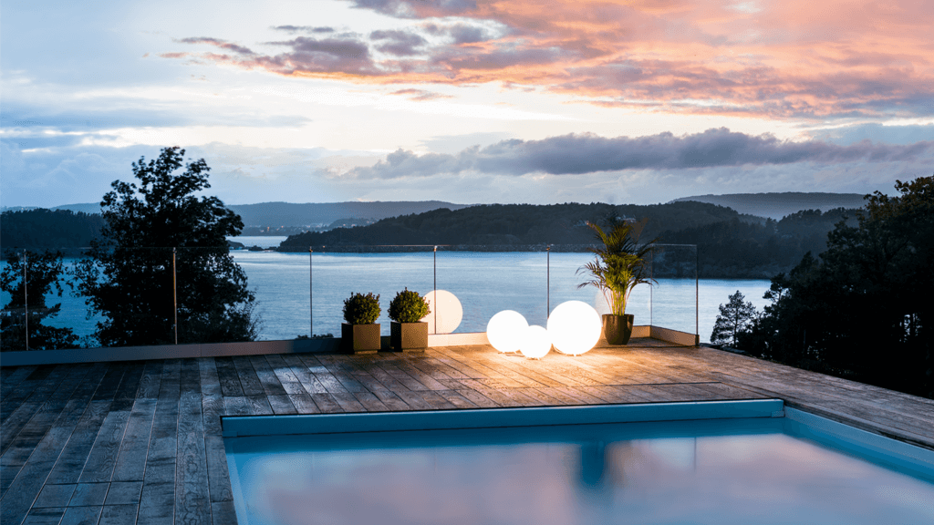Modellen Moon kulelys som er plassert ved et utendørs basseng og lyser opp i skumringen