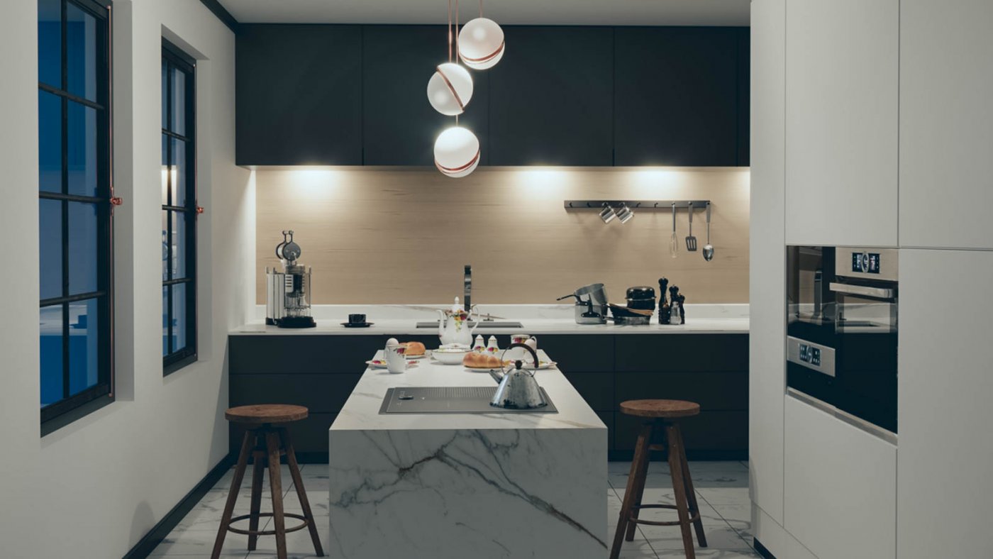Mørke kjøkkenskap med kjøkkenøy i hvit marmor i forgrunnen. Dimmet belysning fra taklampene, og lys over kjøkkenbenken som lyser opp rommet.