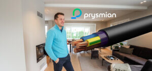 Tarjei Bø i sin nyoppussede stue, med en Prysmian kabel plassert oppå bildet, og logoen til Prysmian med hvit logotype over.